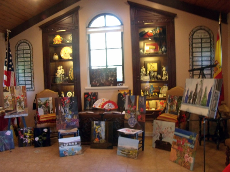 A room with a window and paintings exhibited in front.