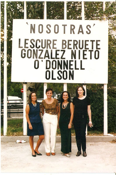 Four young women standing in front of a billboard with their names on it.