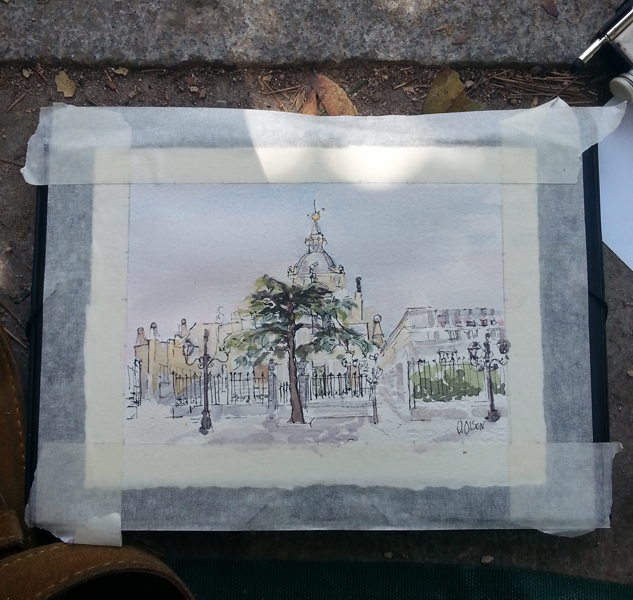 A small watercolor of the Almudena taped down to a drawing board. There is a big evergreen in front of the gate. The Almudena is seen from accross the street.