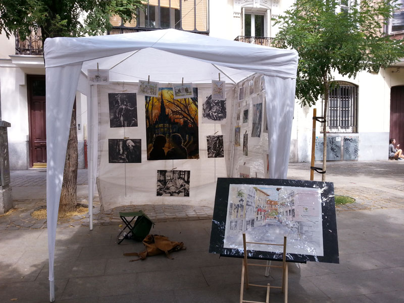 A white tent at Plaza de los Pintores with watercolors, prints and oil paintings